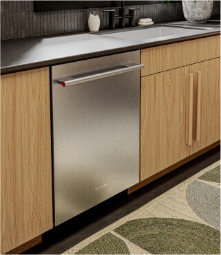 A KitchenAid® dishwasher surrounded by light brown cabinets