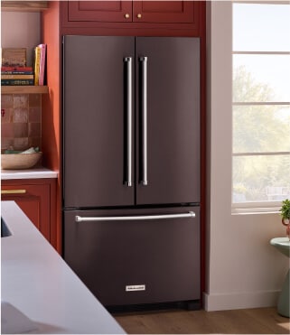 A KitchenAid® refrigerator surrounded by brown cabinetry