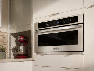 A KitchenAid® microwave with a stand mixer in the background