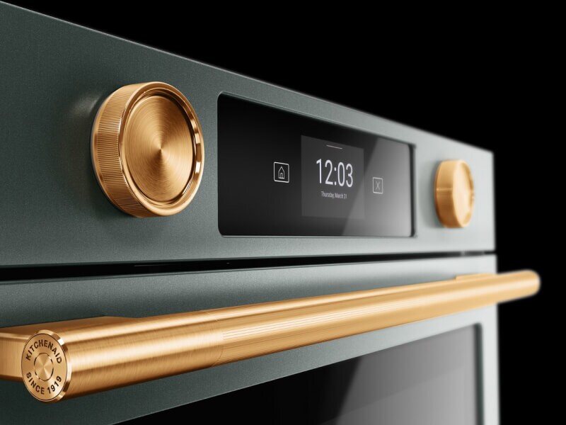 Close up of the golden knobs and handle on a wall oven