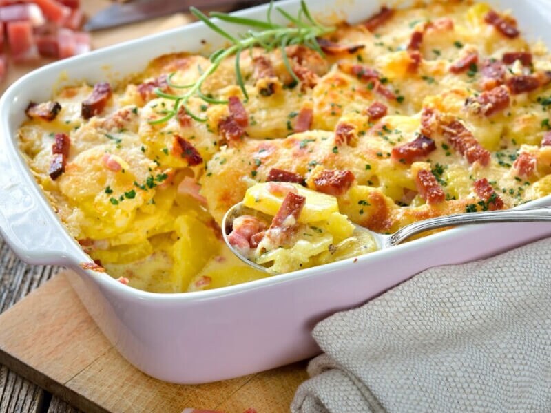 Spoon in an au gratin dish inside a white casserole pan
