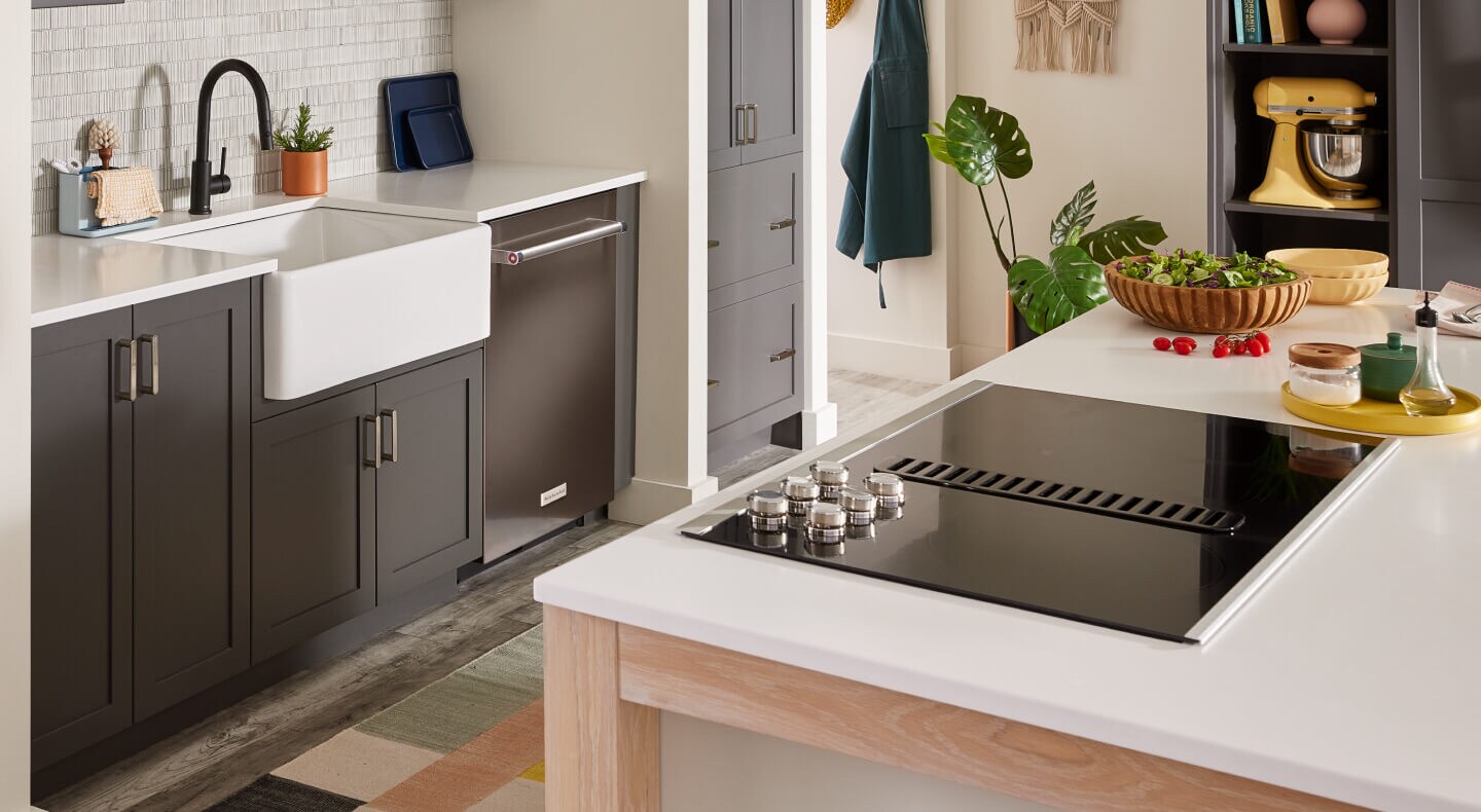 A modern kitchen with an electric downdraft cooktop set into a kitchen island