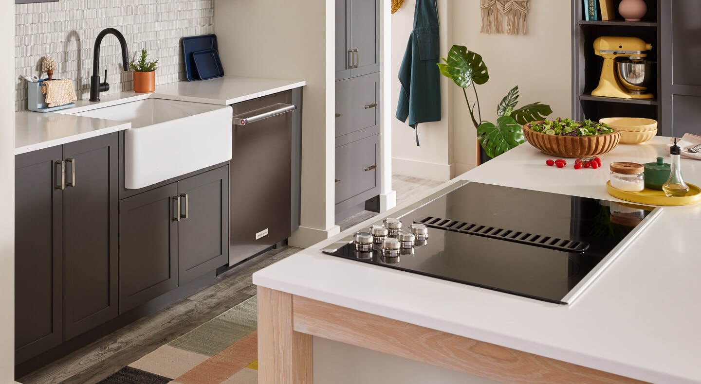 A modern kitchen with an electric downdraft cooktop set into a kitchen island