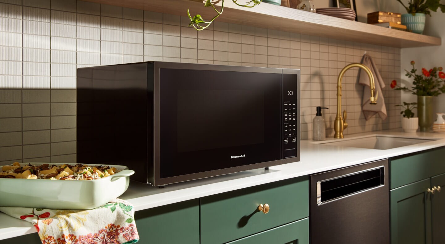 KitchenAid® countertop microwave above green cabinetry