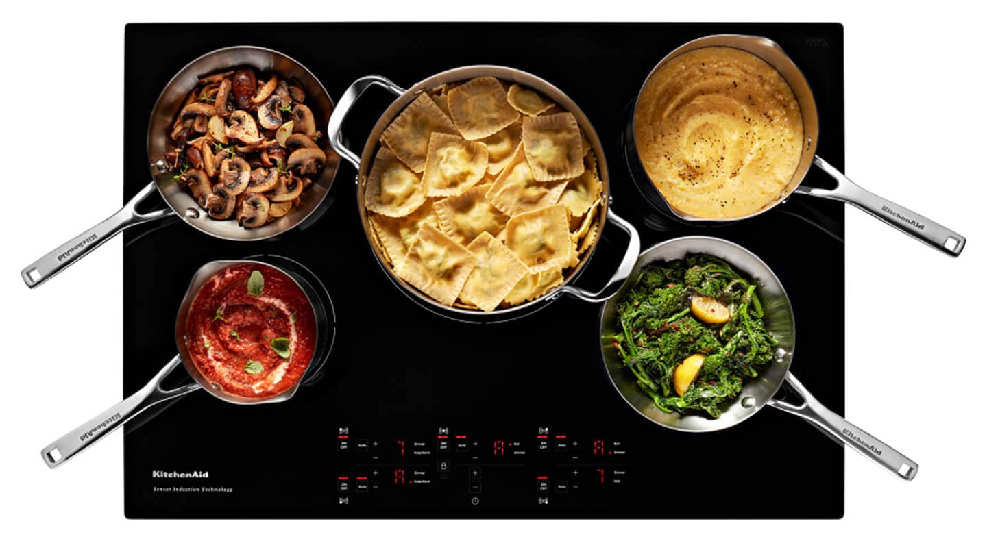 Overhead view of an induction cooktop surface with food Overhead view of an induction cooktop surface with food