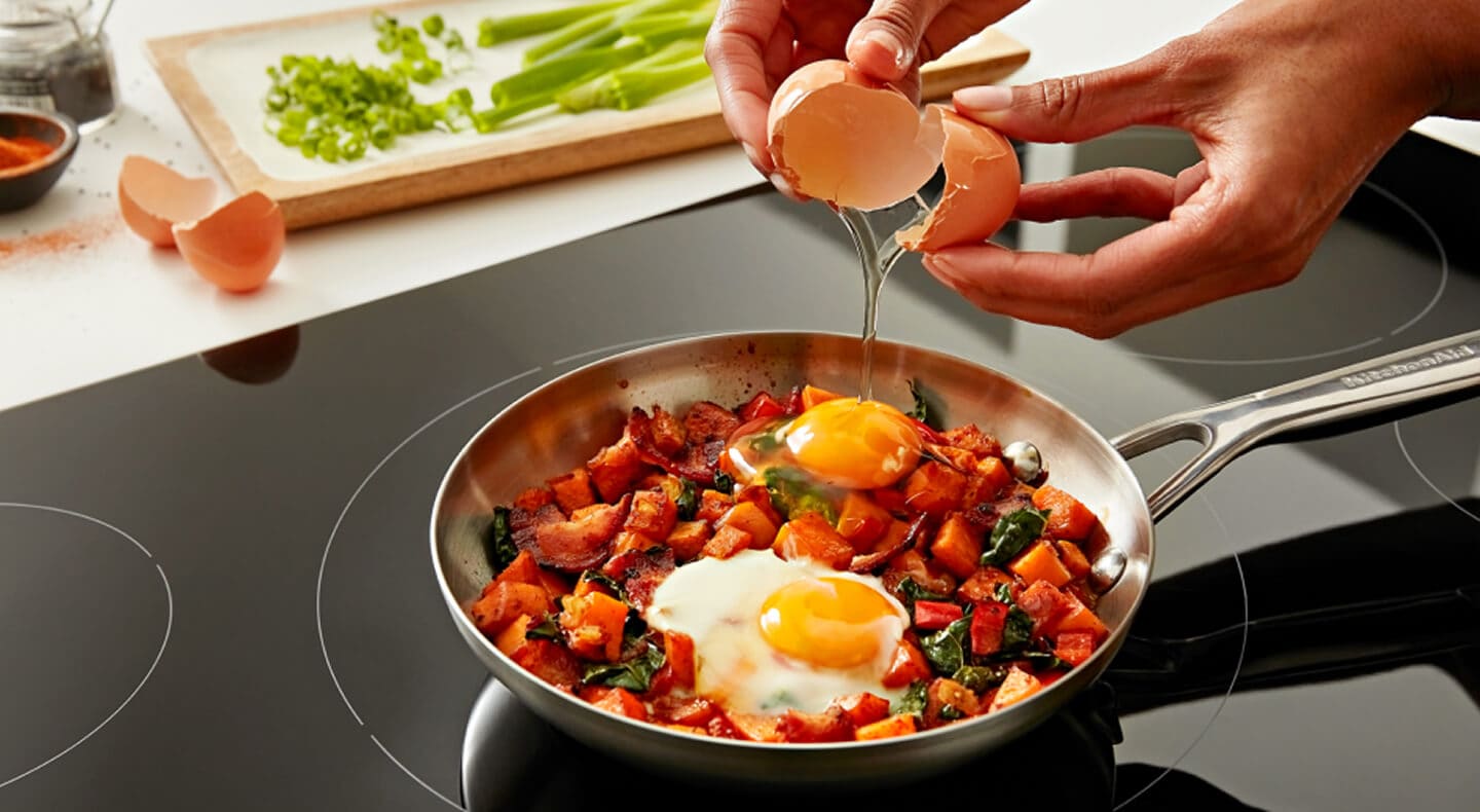 Person cooking on induction cooktop Person cooking on induction cooktop