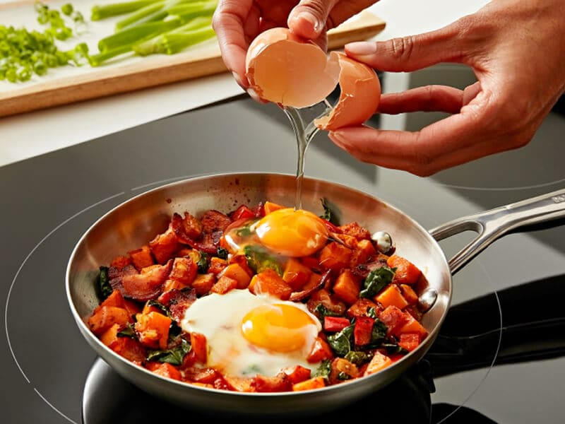 Person cooking on induction cooktop Person cooking on induction cooktop