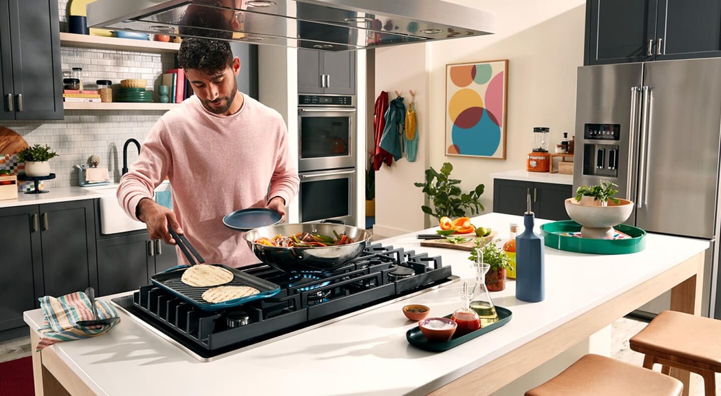 Person cooking on the griddle attachment of a gas stovetop Person cooking on the griddle attachment of a gas stovetop