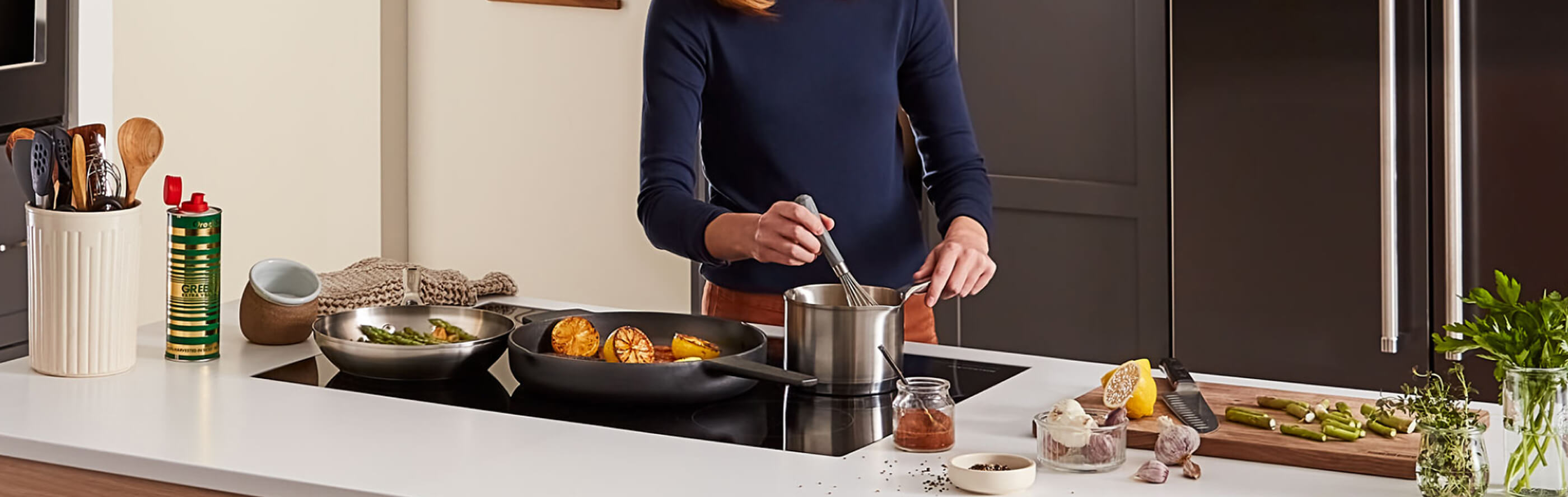Person stirring food in sauce pan on an induction stovetop