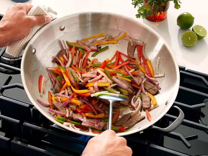 Someone cooking veggies in a pan