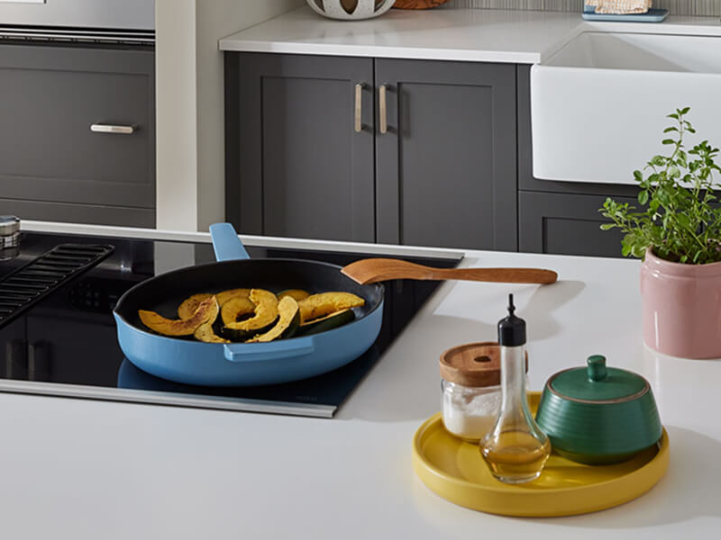 veggies in a pan on a cooktop installed in a kitchen island