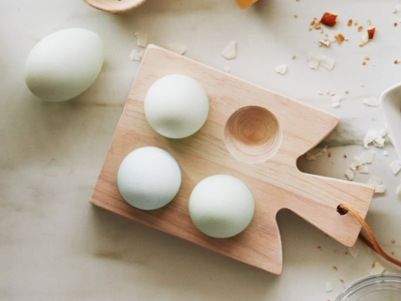 Four eggs on a wooden platter