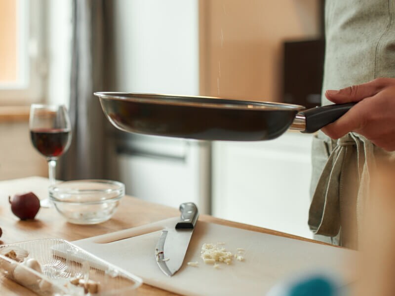 A skillet being held above a counter