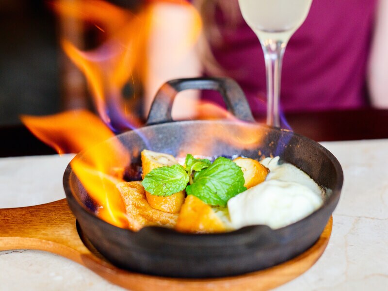Skillet with food being flambéed
