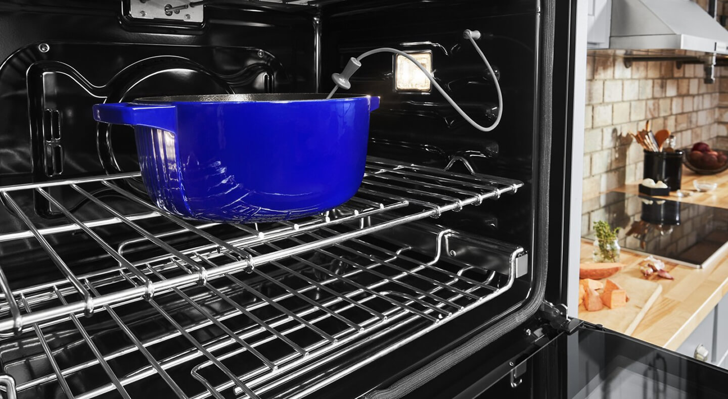 Blue casserole dish in an oven with a temperature monitor in it Blue casserole dish in an oven with a temperature monitor in it