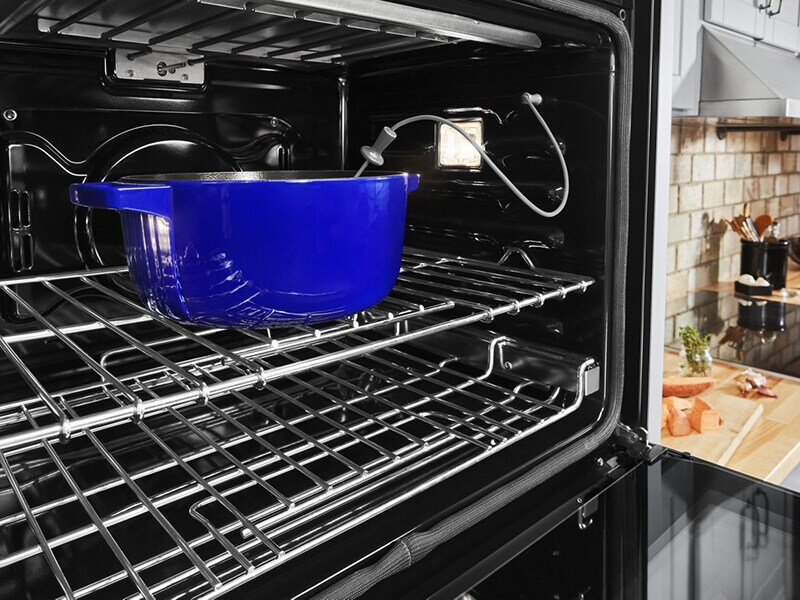 Blue casserole dish in an oven with a temperature monitor in it Blue casserole dish in an oven with a temperature monitor in it