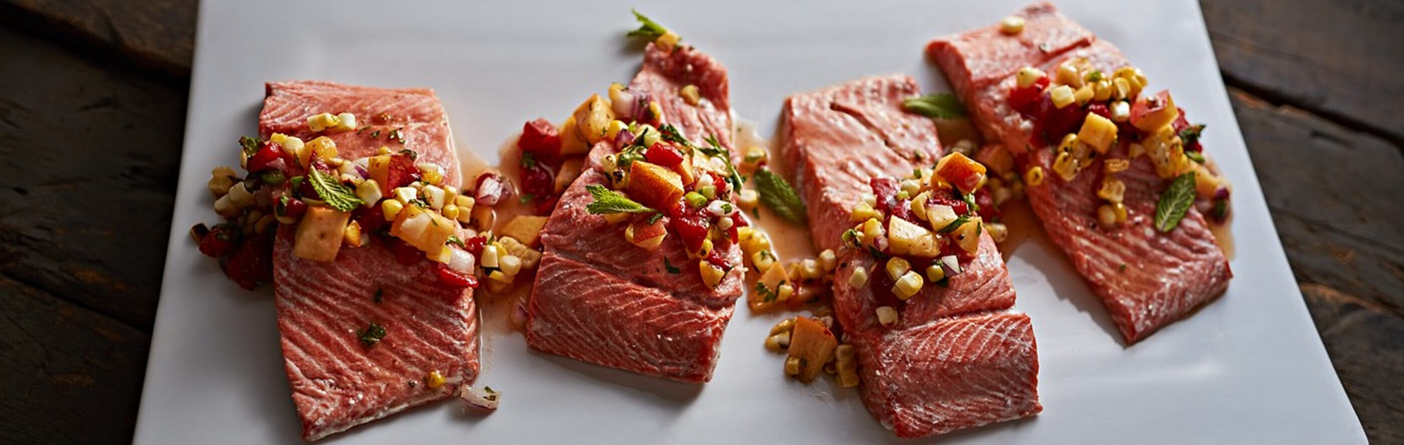 Seasoned salmon before being cooked using the sous vide method on a rustic table
