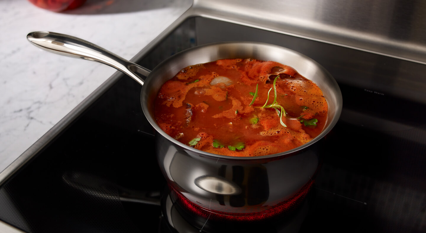 A pot filled with food cooking on a rangetop