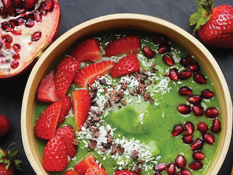 Close-up of green smoothie bowl with strawberries and pomegranate seeds Close-up of green smoothie bowl with strawberries and pomegranate seeds