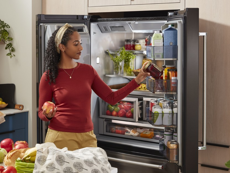 Person putting food in a French-door refrigerator