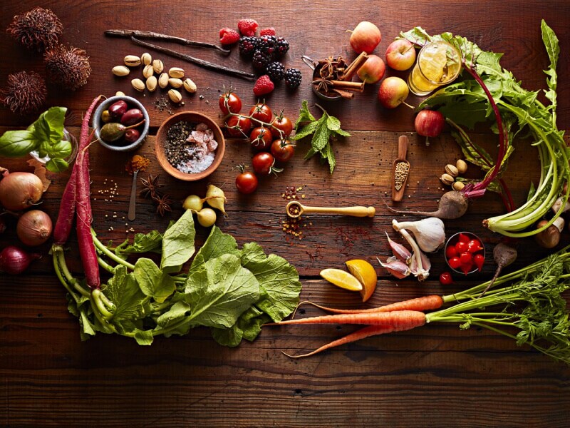 Various vegetables artfully arranged on a rustic wooden countertop