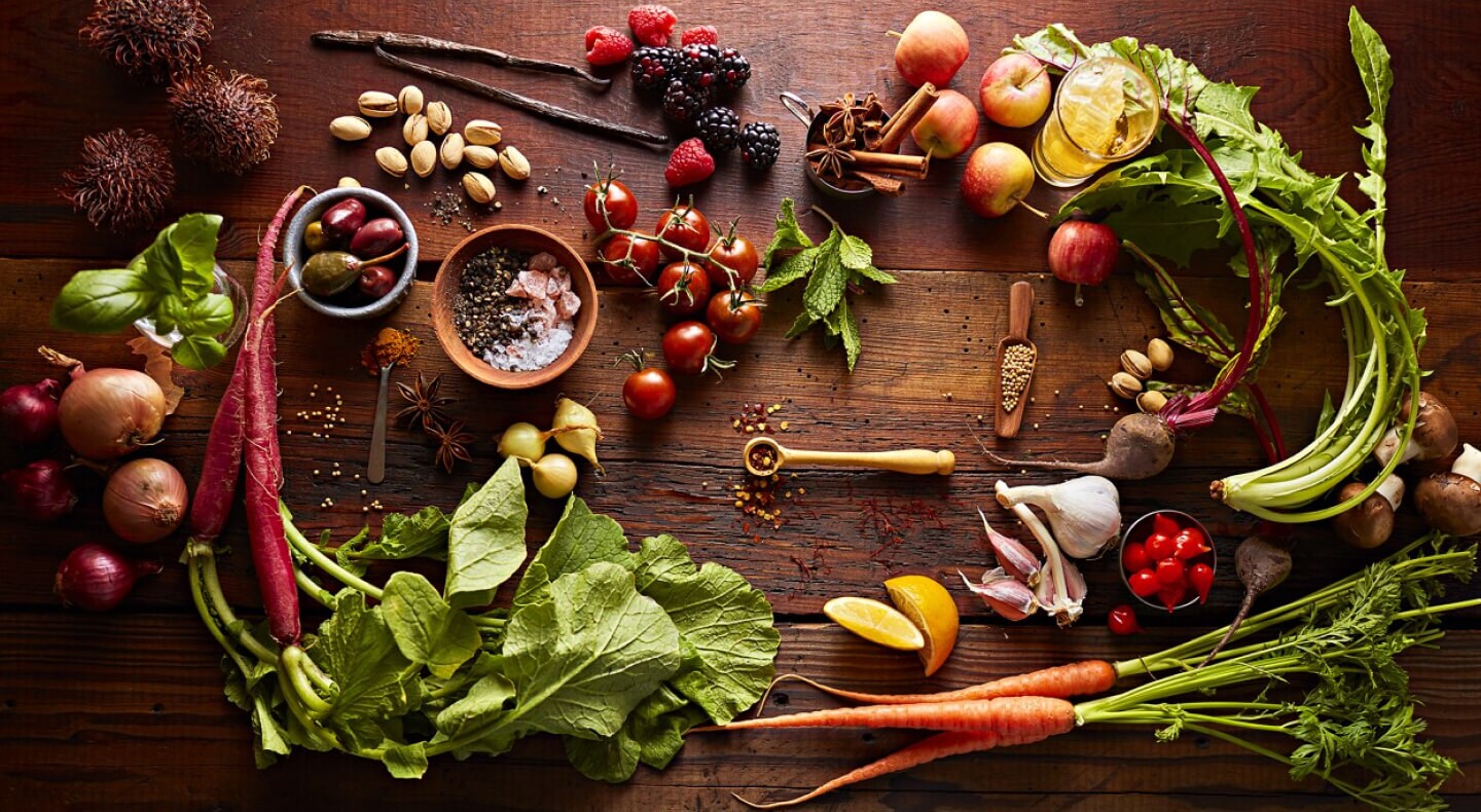 Various vegetables artfully arranged on a rustic wooden countertop