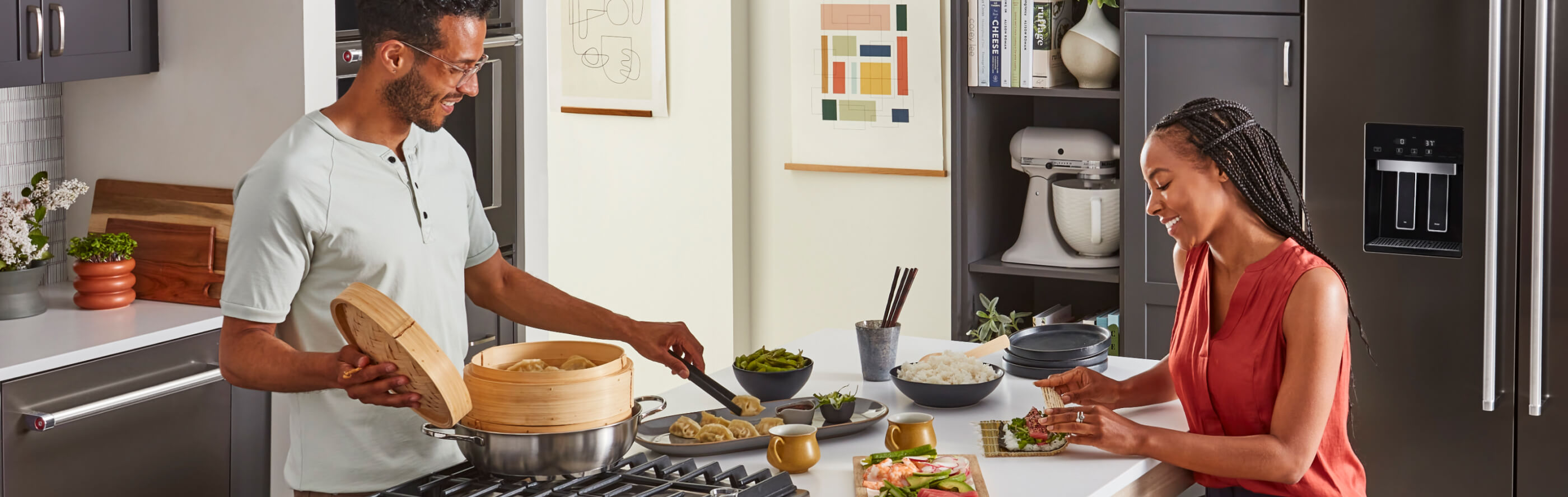 A man and woman cooking together at a kitchen island