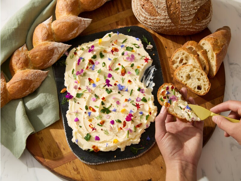 A person spreading butter on crostini. A person spreading butter on crostini.