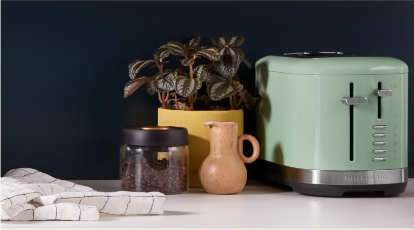 A KitchenAid 2 Slice Toaster against a black backsplash