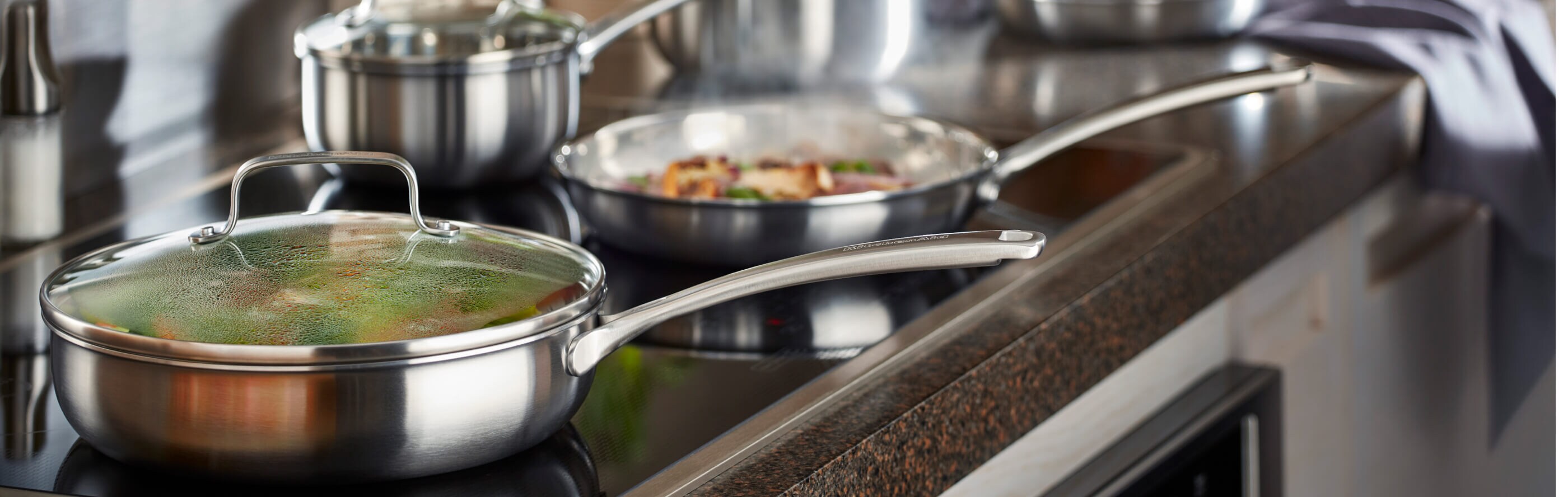 A stainless steel skillet on a KitchenAid brand induction cooktop