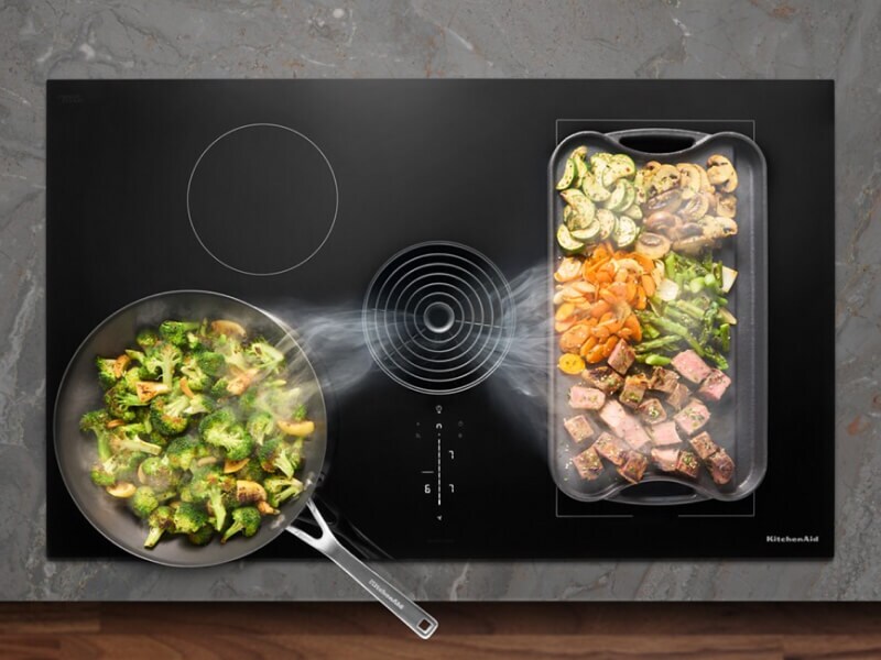 Food cooking on a KitchenAid® induction downdraft cooktop