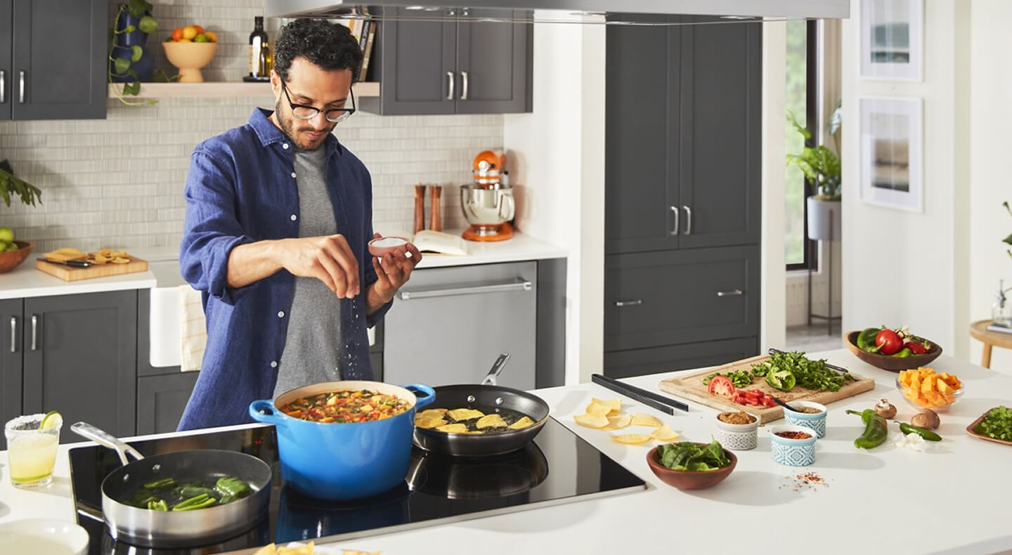 A person salting their food atop an induction cooktop