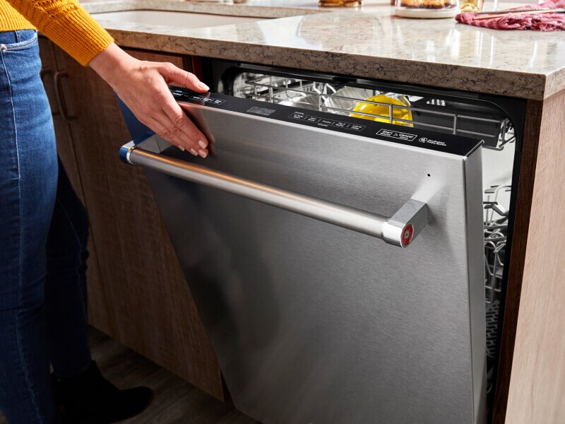 Title Needed A hand closing a top control built-in dishwasher with a towel bar handle