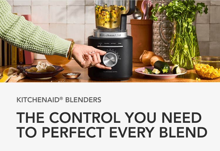 Hand turning the knob on a matte black KitchenAid®️ blender with salsa inside