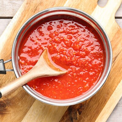 Someone stirring sauce in a pot