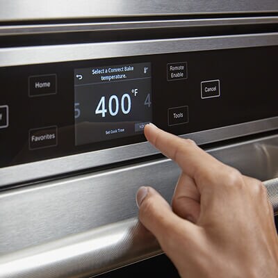 Someone operating the control panel on their oven