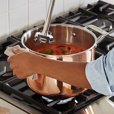 Someone blending sauce on a stovetop