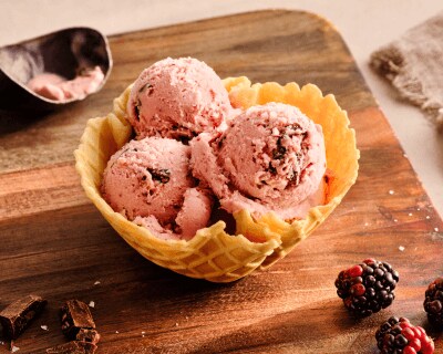 Three scoops of ice cream in a waffle cone bowl