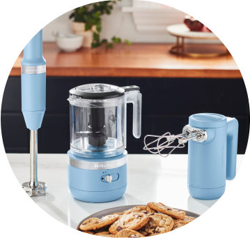 Blue Velvet KitchenAid® Cordless Immersion Blender, Food Chopper, and Hand Mixer on white countertop.