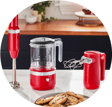 Passion Red KitchenAid® Cordless Immersion Blender, Food Chopper, and Hand Mixer on white countertop.