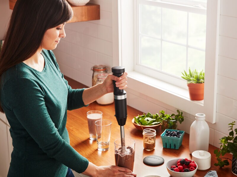 Person using a KitchenAid® cordless hand blender Person using a KitchenAid® cordless hand blender