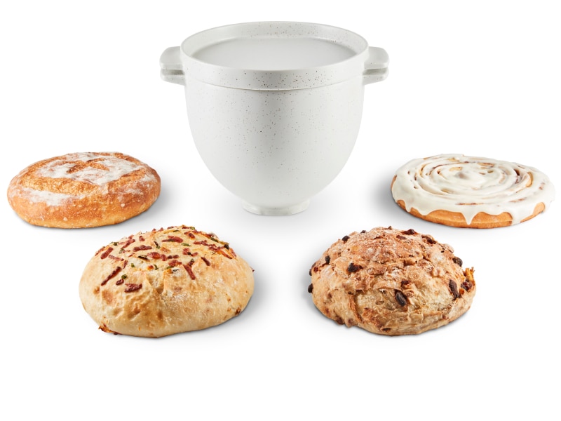 KitchenAid® bread bowl with baking lid surrounded by a variety of bread
