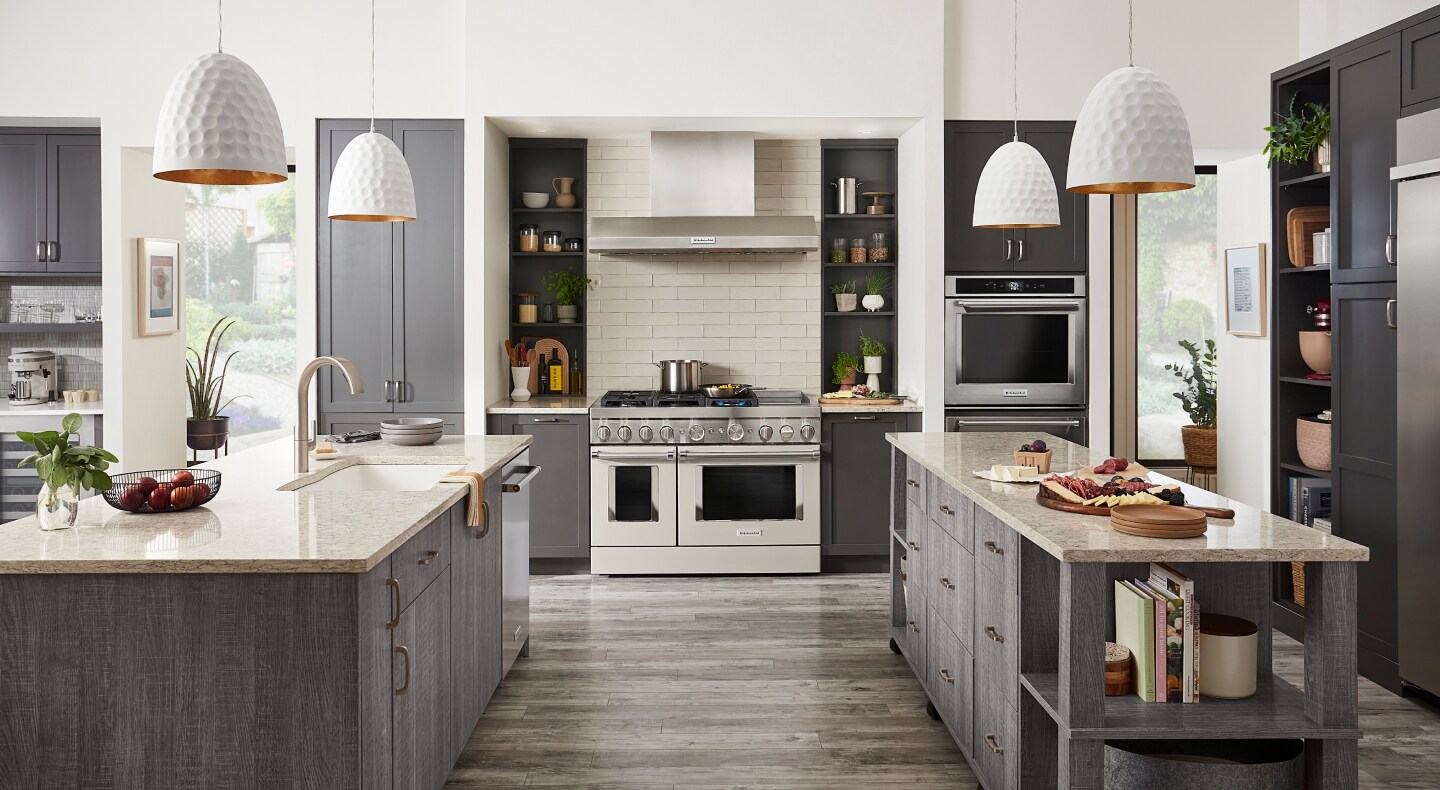 Kitchen with two islands, commercial style range and gray cabinets