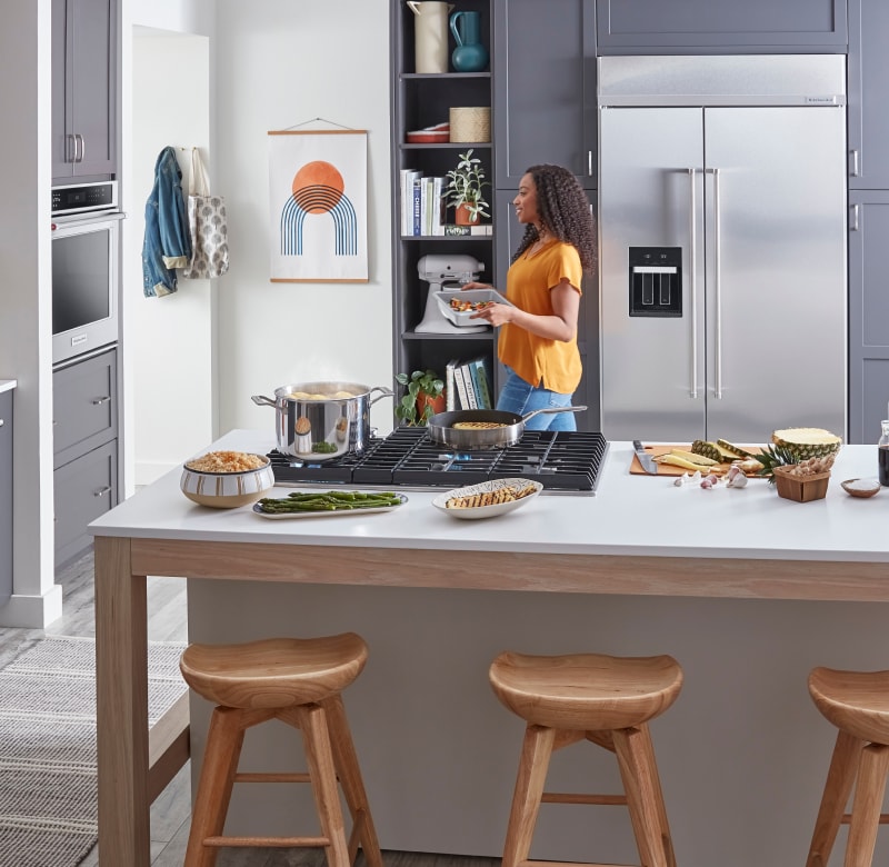 Woman preparing to place roasting pan in wall oven
