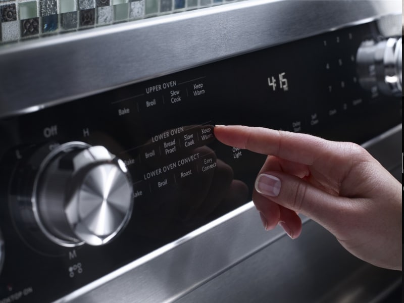 Close-up of a person selecting settings on an oven