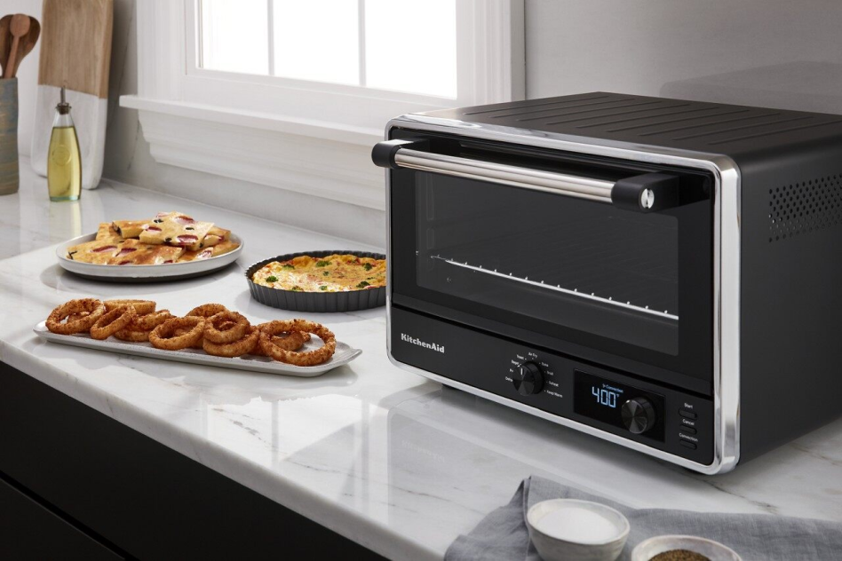 Air-fried onion rings on countertop next to KitchenAid® Countertop Oven with Air Fry. Air-fried onion rings on countertop next to KitchenAid® Countertop Oven with Air Fry.
