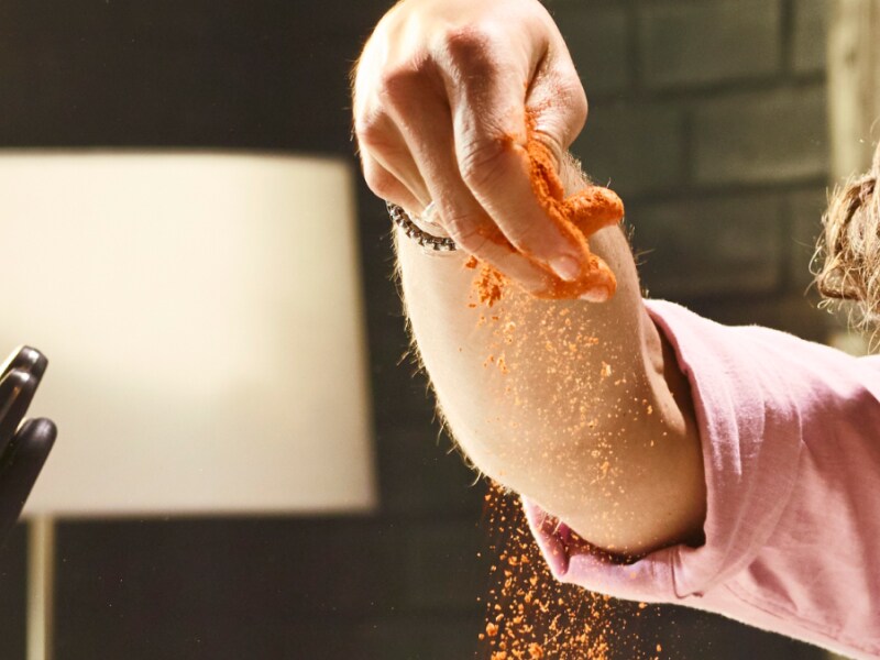 A person sprinkling seasoning