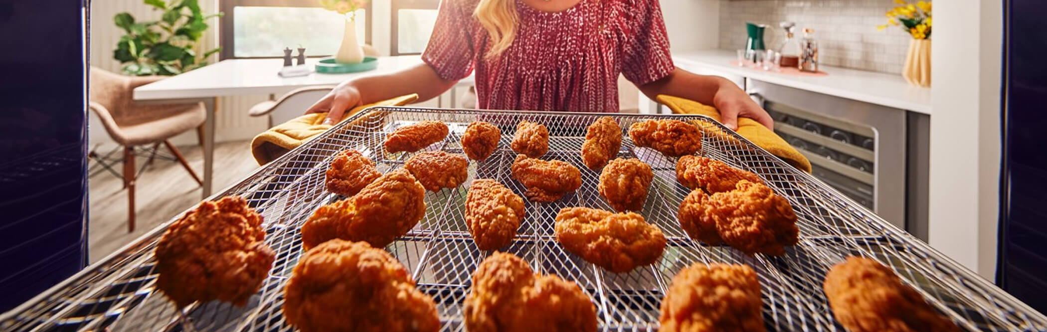 Person removing fried chicken from an air fryer