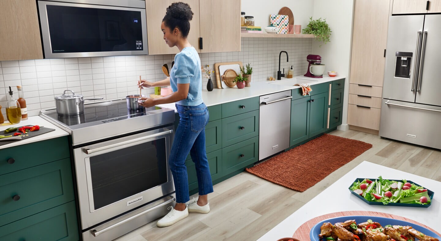 A person stirring a pot on their stove A person stirring a pot on their stove