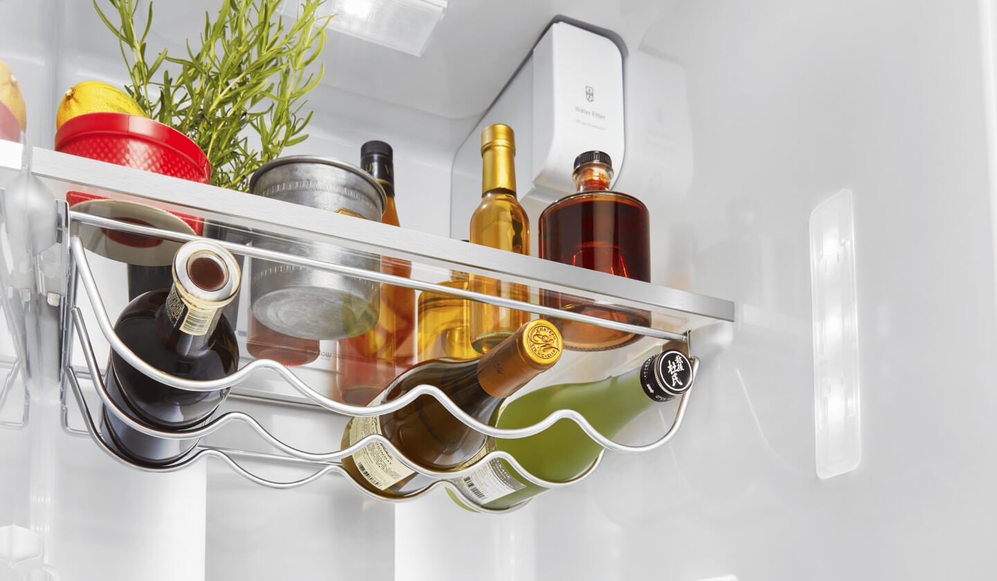 Bottles of wine resting on an interior refrigerator rack Bottles of wine resting on an interior refrigerator rack